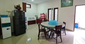 a kitchen with a table with chairs and a refrigerator at Rumah Kalimanjung in Ngingas