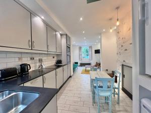 a kitchen with white cabinets and a table and chairs at Lovely contemporary ground floor apartment. in Dean