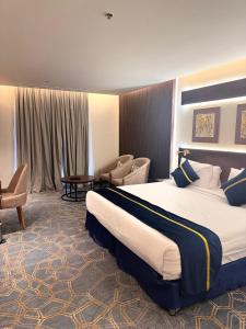 Pokój hotelowy z dużym łóżkiem i krzesłem w obiekcie فندق سنبات بلاتينيوم w mieście Dżizan