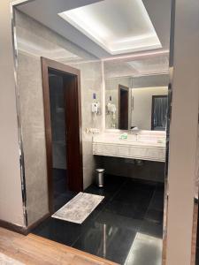 un bagno con due lavandini e un grande specchio di فندق سنبات بلاتينيوم a Jazan