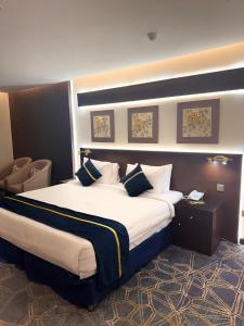 um quarto de hotel com uma cama grande com almofadas em فندق سنبات بلاتينيوم em Jazan