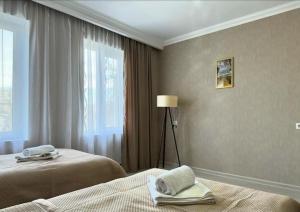 ein Hotelzimmer mit zwei Betten und einem Fenster in der Unterkunft Tamari See in Dedoplis Tskaro + 63 Fotos