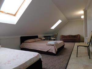 a bedroom with two beds and a couch and a window at Hotel & Banquet Hall SV Airport Parkway in Todoreshty
