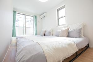 a large white bed in a room with a window at Comfort Walk to Takadanobaba Sta. - 3LDK SoYi / Dual Bathrooms & Washrooms for Families & Groups in Tokyo