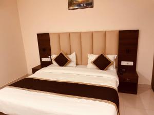 um quarto com uma cama grande e 2 almofadas em Gamla INN, Munnar em Munnar