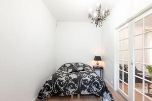 um quarto com uma cama com um edredão preto e branco em Cosy, brand new apartment in best area em Helsinque