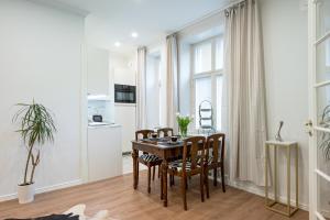 uma cozinha e sala de jantar com mesa e cadeiras em Cosy, brand new apartment in best area em Helsinque