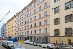 ein großes Gebäude mit davor geparkt in der Unterkunft Cosy, brand new apartment in best area in Helsinki