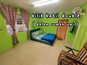 ein Schlafzimmer mit einem Bett in einem grünen Zimmer in der Unterkunft Dangau TokWan in Pokok Sena