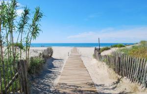 un sentiero in legno per la spiaggia con l'oceano sullo sfondo di Stunning Home In Saint-Laurent-De-La-Cabrerisse a Saint-Laurent-de-la-Cabrerisse Altre 23 foto