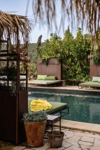a pool with two beds and a table next to it at Finca Legado Ibiza in Santa Eularia des Riu