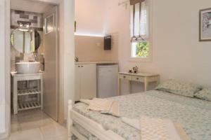 a white bedroom with a bed and a sink at Villa Jasmin Studios 2 in Gouvia