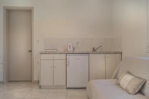a white kitchen with a counter and a sink at Villa Jasmin Studios 2 in Gouvia +14 photos
