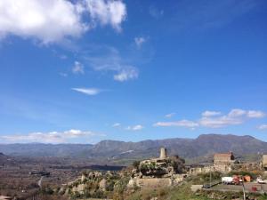 an old building on a hill with mountains in the background at Affittacamere Bellavista in Castiglione di Sicilia
