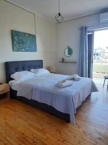 - une chambre avec un lit et des serviettes dans l'établissement Comfort apartment in the city, à Kalamata