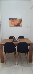 une table en bois avec des chaises et une plaque de cuisson. dans l'établissement Comfort apartment in the city, à Kalamata