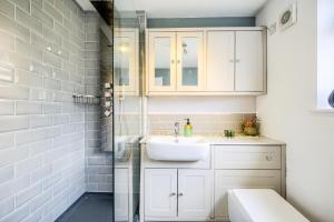uma casa de banho branca com um lavatório e um chuveiro em Warwickshire Beautiful Cottage, 2 dbl bed Sleeps 4 by EMPOWER HOMES em Kenilworth