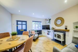 a living room with a table and a fireplace at Warwickshire Beautiful Cottage, 2 dbl bed Sleeps 4 by EMPOWER HOMES in Kenilworth