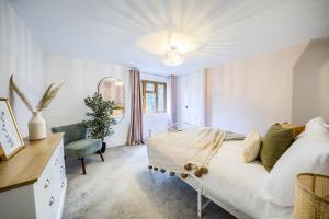 a white bedroom with a bed and a chair at Warwickshire Beautiful Cottage, 2 dbl bed Sleeps 4 by EMPOWER HOMES in Kenilworth