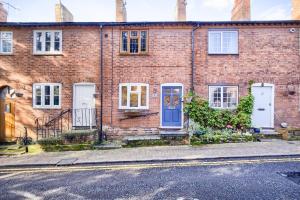 a brick house with a blue door and windows at Warwickshire Beautiful Cottage, 2 dbl bed Sleeps 4 by EMPOWER HOMES in Kenilworth