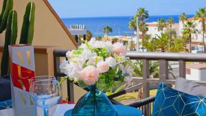 a blue vase with flowers on a table on a balcony at Sea view el veril in Adeje