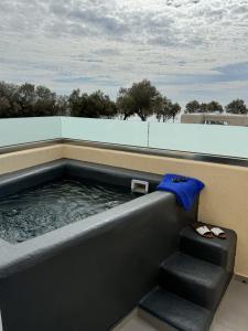 a jacuzzi tub with a blue towel and stairs at Perissa Bay in Perissa