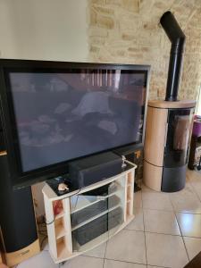 uma grande televisão de ecrã plano sentada numa bancada em Monis ruhiges Ferienhaus em Ménétreuil