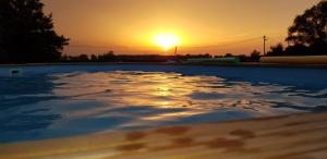 une piscine avec le coucher de soleil en arrière-plan dans l'établissement Monis ruhiges Ferienhaus, à Ménétreuil
