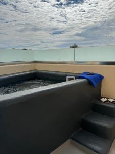 a hot tub with a blue towel sitting next to stairs at Perissa Bay in Perissa