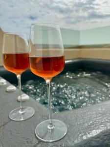 two glasses of wine sitting on top of a bath tub at Perissa Bay in Perissa