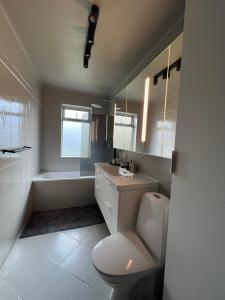 a bathroom with a toilet and a sink and a tub at B17 Apartment in Njarðvík