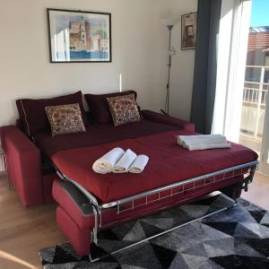 uma cama vermelha com duas toalhas brancas em LGM Charming Apartment em Nápoles