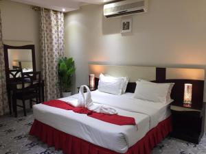 Habitación de hotel con cama con manta roja en Merfal Hotel Apartments Al Taawan مرفال التعاون, en Riad