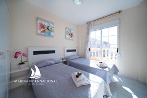 een slaapkamer met 2 bedden en een raam bij Apartamentos Marina Internacional in Torrevieja