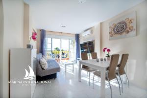 une salle à manger avec une table et des chaises blanches dans l'établissement Apartamentos Marina Internacional, à Torrevieja