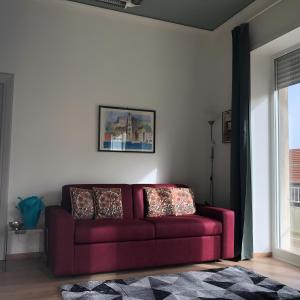 um sofá vermelho numa sala de estar com uma janela em LGM Charming Apartment em Nápoles