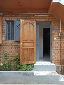 an entrance to a brick building with a wooden door at Chez Jeanne Auberge Antananarivo in Talata-maty +49 photos