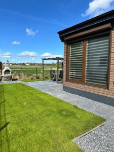 a patio with a gazebo next to a yard at Ferienhaus am Seepark -J&K in Goch