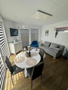 een woonkamer met een tafel en stoelen en een bank bij Ferienhaus am Seepark -J&K in Goch