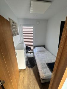 Kleines Zimmer mit einem Bett und einem Schreibtisch. in der Unterkunft Ferienhaus am Seepark -J&K in Goch