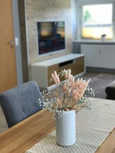 um vaso com flores numa mesa numa sala de estar em fewo-friends em Reinfeld