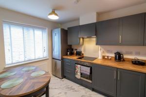 cocina con mesa de madera y encimera de madera en Pass the Keys Modern comfortable House, en Elswick