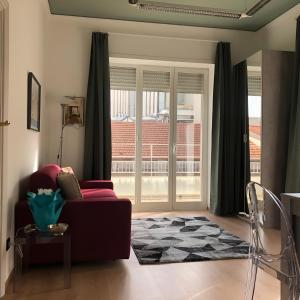 uma sala de estar com um sofá vermelho e uma porta de vidro deslizante em LGM Charming Apartment em Nápoles