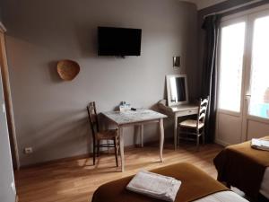 mały pokój ze stołem i telewizorem w obiekcie Logis Hôtel Restaurant La Borie w mieście Saint-Geniès