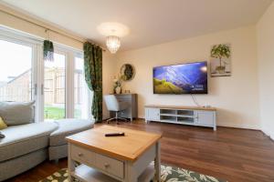 sala de estar con sofá y TV en la pared en Pass the Keys Modern comfortable House, en Elswick
