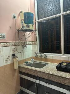 uma pequena cozinha com um lavatório e uma janela em Entire House- Ground Floor- Raj Villa em Kanpur