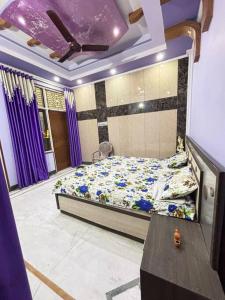 um quarto com uma cama num quarto com cortinas roxas em Entire House- Ground Floor- Raj Villa em Kanpur