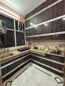 uma cozinha com armários de madeira e um lavatório em Entire House- Ground Floor- Raj Villa em Kanpur