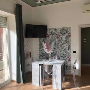 um quarto com uma mesa e uma televisão na parede em LGM Charming Apartment em Nápoles