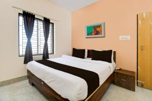 a bedroom with a large bed and a window at OYO ALYSAN STAY in Bhubaneshwar